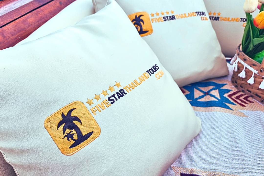Pillows Branded With Five Star Thailand Tours Logo On Longtail Boat